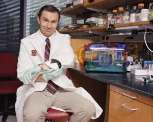 Harvard professor David Sinclair in his lab holding a lab mouse, representing his research on aging and the longevity supplements he personally uses.