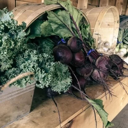 Bundles of fresh kale and beets displayed on a rustic wooden table, rich in antioxidants and natural compounds believed to support cellular health and reverse aging.